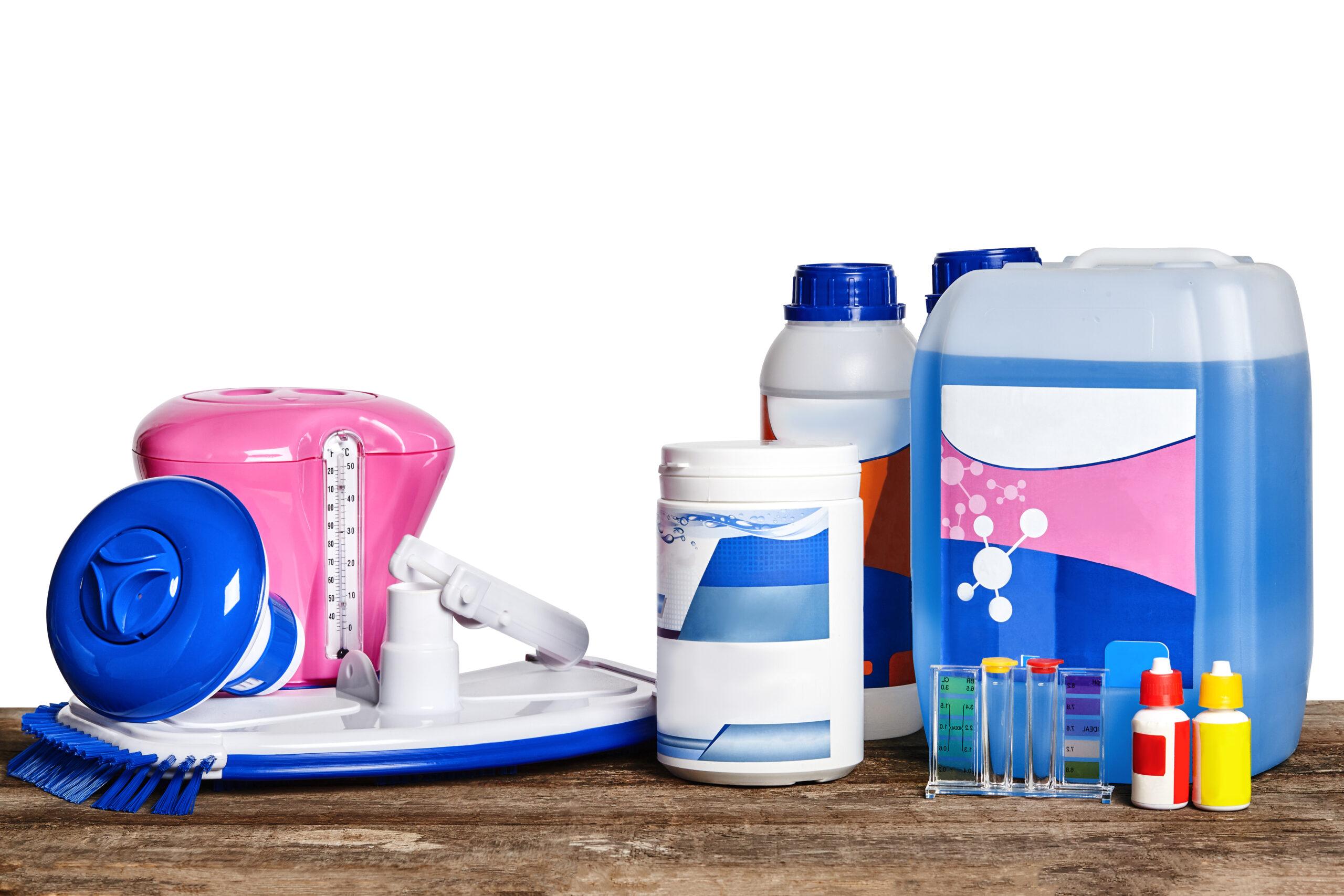 Equipment with chemical cleaning products and tools for the maintenance of the swimming pool on a wooden surface against white background.
